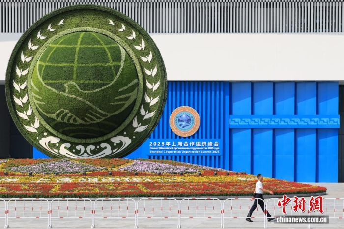 8月31日，天津，一名工作人員從2025年上海合作組織峰會(huì)主會(huì)場外的景觀花壇旁經(jīng)過。當(dāng)日，2025年上海合作組織峰會(huì)在天津舉行。<a target='_blank' href='/'><p  align=