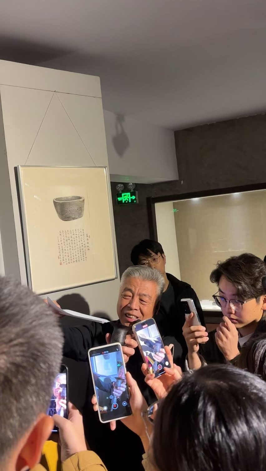 黑陶邢文化博物館館長邢葆東展示兩張相疊的A4紙，向記者解釋此為杯口的厚度。