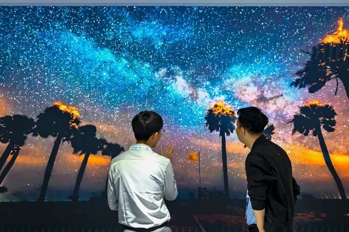 長春光博會希達電子展區(qū)，一位工作人員正在給一位觀眾講解。（長春新區(qū)供圖）