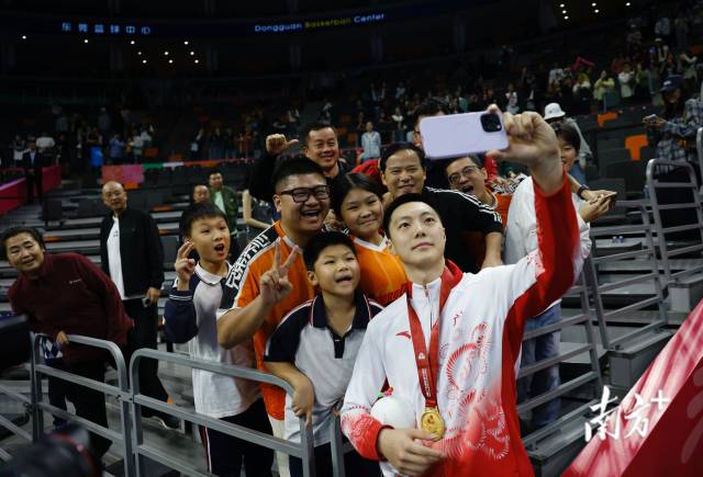 11月12日，十五運會男籃成年組決賽，廣東隊獲得冠軍后，胡明軒與球迷們合影留念。張由瓊 攝