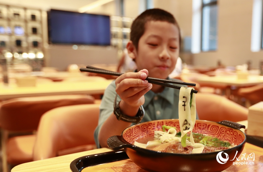殷墟博物館推出的甲骨文面深受游客喜愛。人民網(wǎng)記者 慎志遠 攝