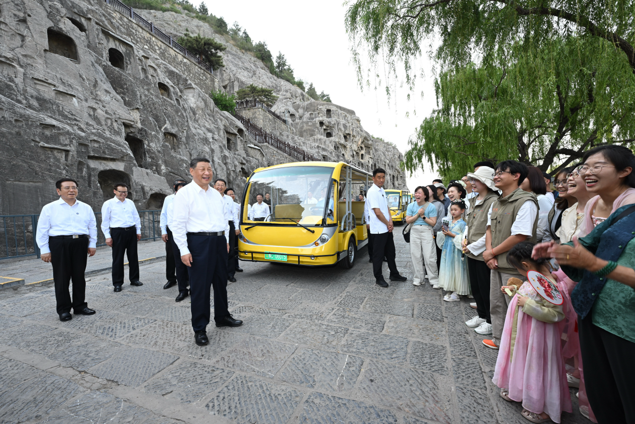 5月19日，習近平在洛陽龍門石窟考察時，同游客親切交流。