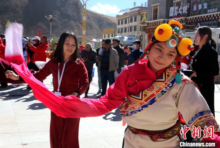 圖為中外記者向當?shù)孛癖妼W(xué)習(xí)民族歌舞文化。　張?zhí)砀?攝