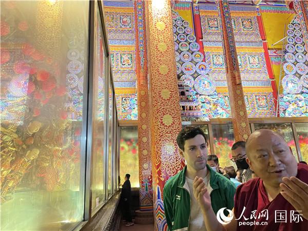 7月25日，省級非物質(zhì)文化遺產(chǎn)項目塔爾寺酥油花的代表性傳承人朋措堅參（右）在塔爾寺酥油花館講解酥油花的制作過程。人民網(wǎng) 謝瑩攝