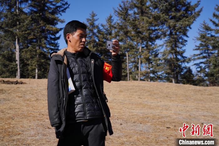 圖為桑杰加進行巡查并拍照記錄?！●R銘言 攝