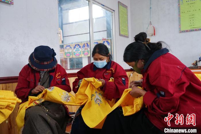 圖為工人正在制作哈達?！●R銘言 攝