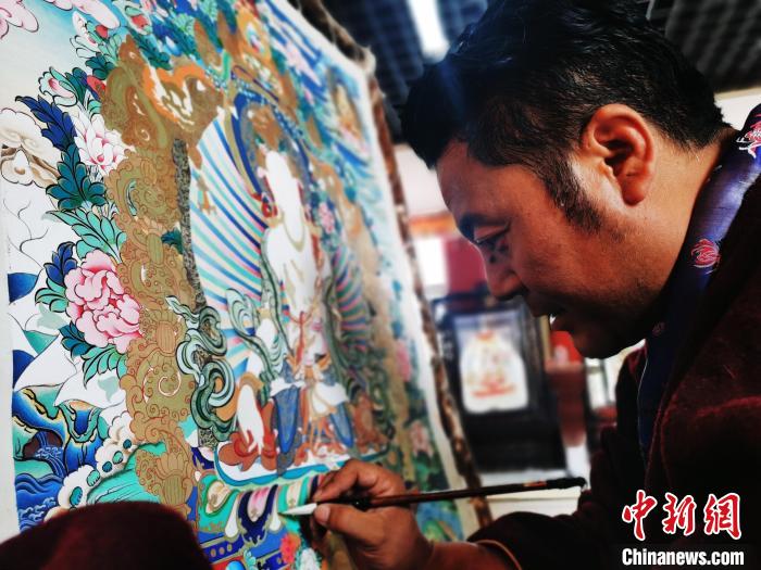 圖為久美尖措創(chuàng)作唐卡?！?zhí)砀?攝