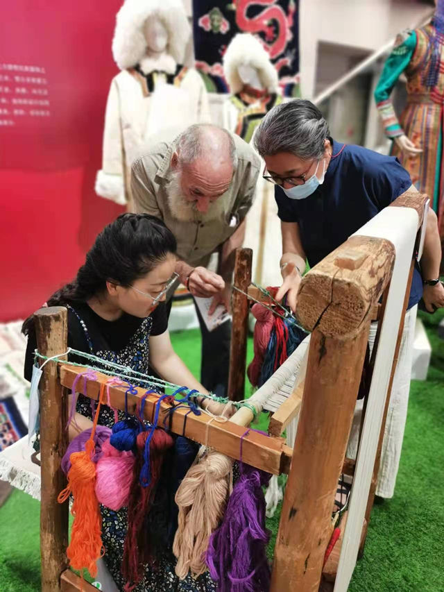楊永良的學(xué)生在展會(huì)上向客商介紹加牙藏毯編織技藝。受訪者供圖