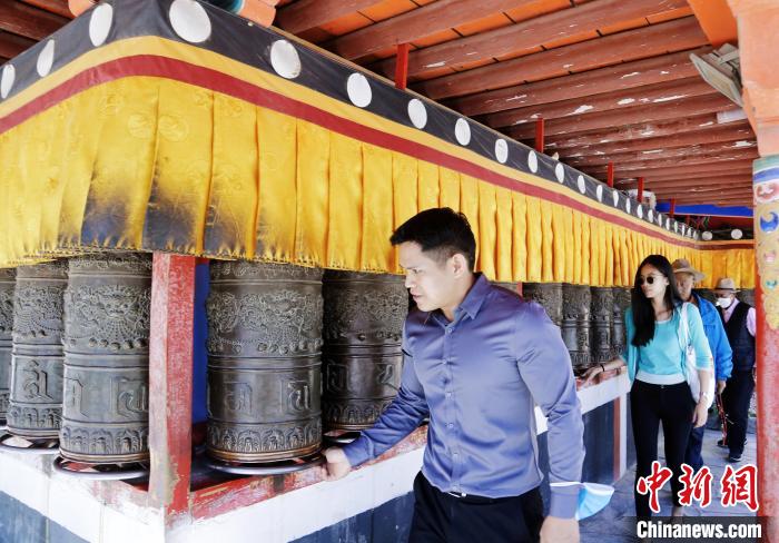 圖為外籍嘉賓體驗(yàn)藏族傳統(tǒng)轉(zhuǎn)經(jīng)筒。　馬銘言 攝