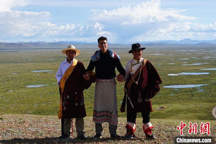 圖為一名留學(xué)生身穿自己國家的服飾和藏族民眾合影留念?！●R銘言 攝