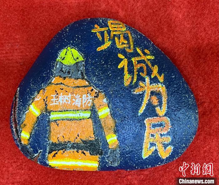 圖為玉樹(shù)消防指戰(zhàn)員創(chuàng)作的石頭畫(huà)作品《逆行在路上》。　孫瑞祥 攝