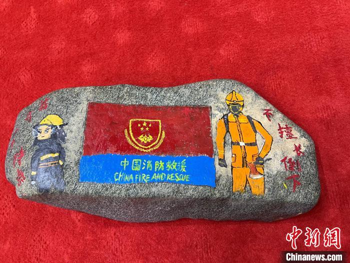圖為玉樹(shù)消防指戰(zhàn)員創(chuàng)作的石頭畫(huà)作品《我有一個(gè)特點(diǎn)“不擅長(zhǎng)倒下”》?！O瑞祥 攝