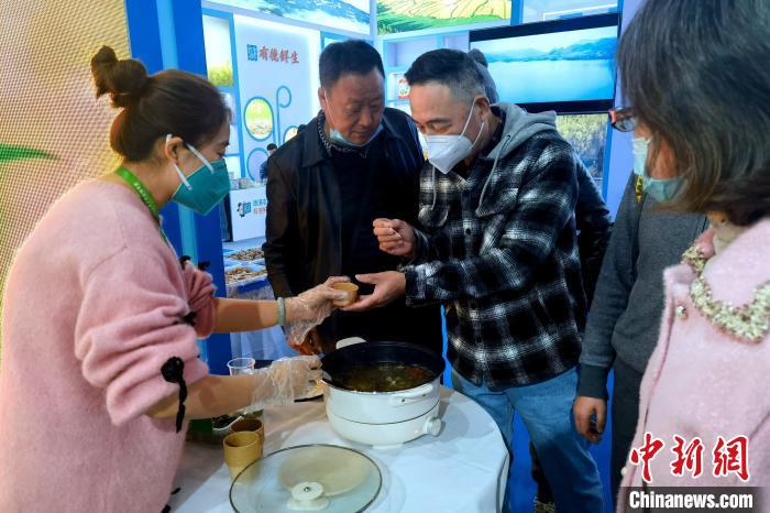 圖為杭州市民品嘗茶卡羊肉?！±铍h 攝