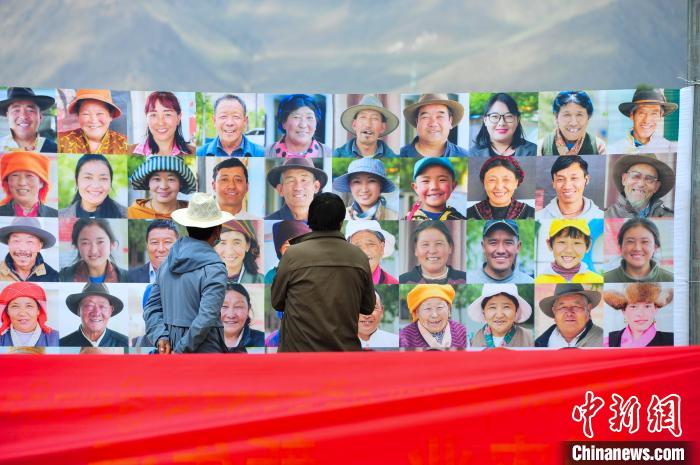 圖為當(dāng)?shù)孛癖娫谟^看展板上的笑臉?！垈?攝