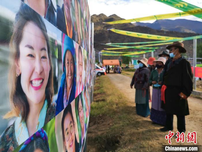 圖為當(dāng)?shù)孛癖娫谟^看展板上的笑臉?！垈?攝