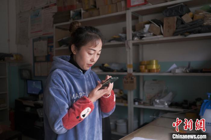 正在快遞站點(diǎn)內(nèi)忙碌的楊莉春?！『闻罾?攝