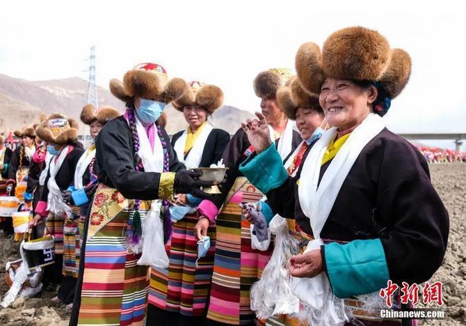 資料圖：西藏自治區(qū)拉薩市曲水縣才納鄉(xiāng)協(xié)榮村參加春耕儀式的村民互敬青稞酒。按照傳統(tǒng)，當地村民身著節(jié)日盛裝，舉行隆重的儀式，祈福一年的豐收。<a target='_blank' ><p  align=