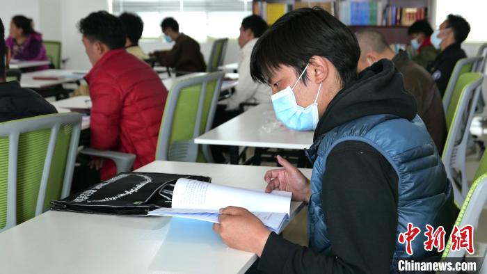 圖為正在閱讀“杰松達(dá)孜”藏歷法教材的學(xué)員?！≈x牧 攝