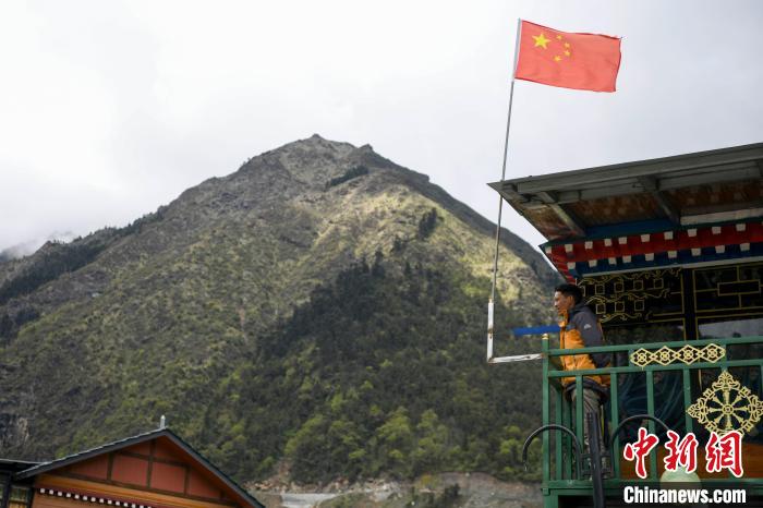 村民站在樓房上觀望?！钊A峰 攝