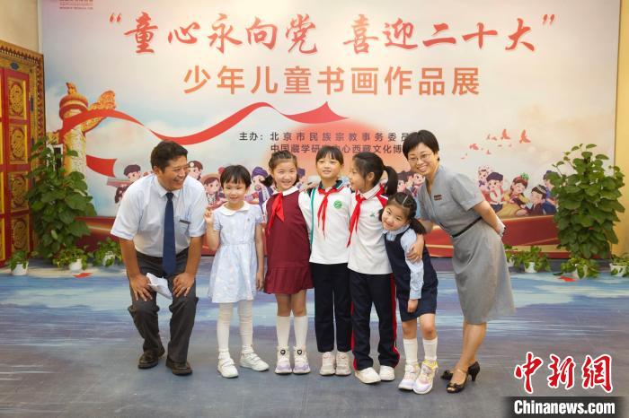 圖為與會嘉賓與入選畫作的“小作者”們在展覽上合影?！≈袊貙W研究中心供圖