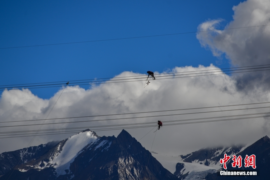 資料圖為2020年6月23日，西藏阿里聯(lián)網(wǎng)工程施工人員在日喀則希夏邦馬雪山附近進(jìn)行走線作業(yè)，安裝絕緣設(shè)備。 <a target='_blank' href='/'><p  align=
