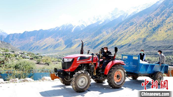 圖為工作人員將把加工完成的糌粑運送至村民手中?！〖卫杩h融媒體中心供圖