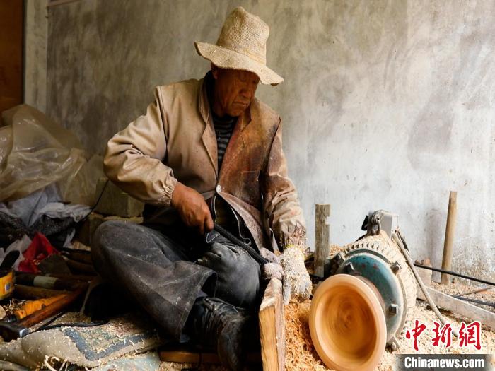 圖為手工藝人正在制作木碗?！?鄧海平 攝