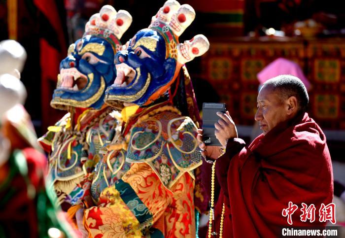 2月19日，正在拍攝跳神活動(dòng)的僧人?！±盍?攝