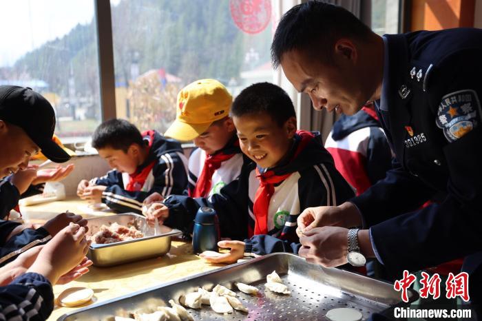圖為亞東邊檢站民警與駐地小學(xué)生其樂融融包餃子。　胡利媛 攝