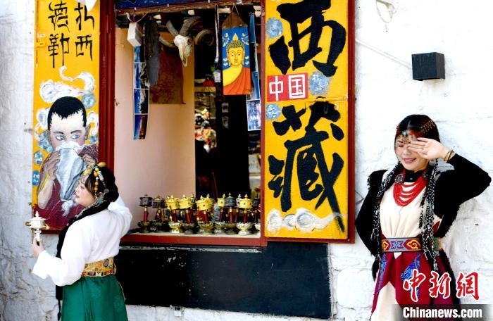 4月17日，游客身著藏式元素服裝在拉薩八廓街拍照留念?！±盍?攝