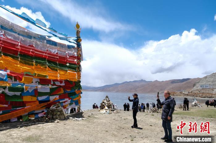 進藏參訪嘉賓在羊湖畔拍攝經(jīng)幡?！〗w波 攝