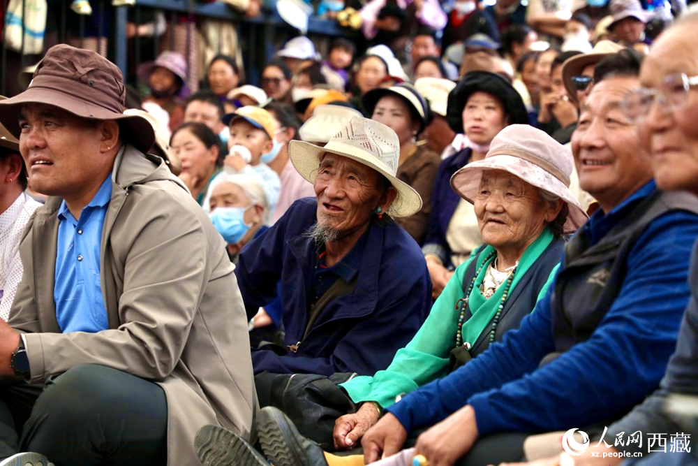 當(dāng)?shù)厝罕姾陀慰陀^看藏戲演出。