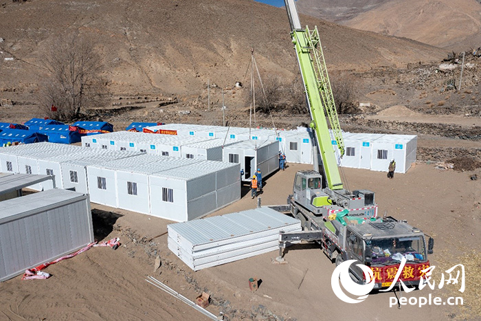 1月9日，在日喀則市定日縣長所鄉(xiāng)古榮村安置點，救援人員和施工人員合力抓緊搭建移動板房，確保受災(zāi)群眾溫暖過冬。人民網(wǎng)記者 翁奇羽攝