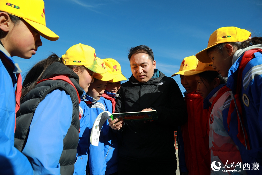 西藏自治區(qū)藏醫(yī)院專家為拉東村小學(xué)生講解天文歷算原理，孩子們圍站聆聽，感受傳統(tǒng)智慧與現(xiàn)代科普的融合。人民網(wǎng)記者 吳雨仁攝