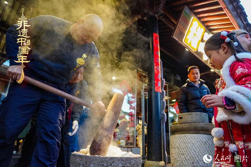 2025年1月29日，浙江省寧波市江北區(qū)慈城古縣城，市民和游客觀看搗年糕。人民網(wǎng) 章勇濤攝