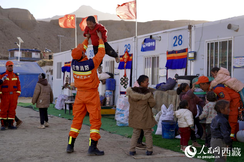 熱木青村安置點(diǎn)，消防員們同孩子們嬉戲玩耍。人民網(wǎng)記者 次仁羅布攝