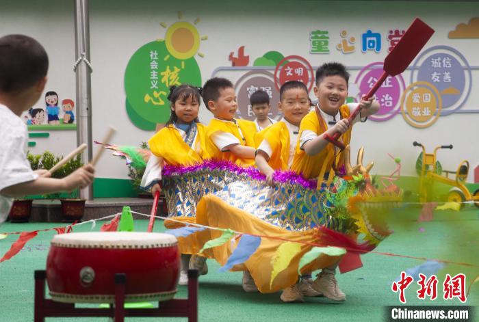 圖為龍舟賽游戲上，小伙伴們打鼓加油?！《^生 攝